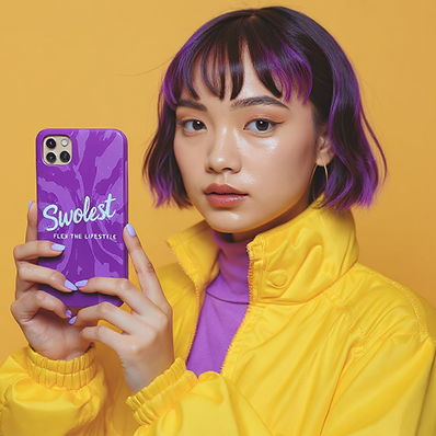 Young person with purple hair holds a purple phone case that says "Swolest." Wears a yellow jacket and purple top, standing against a yellow background.